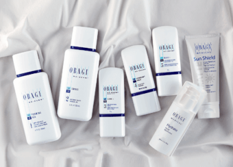 A collection of skincare products neatly arranged on a white fabric surface.