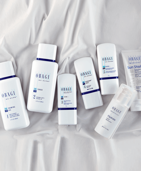 A collection of skincare products neatly arranged on a white fabric surface.