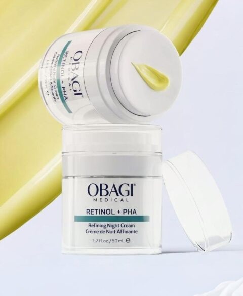 Olay moisturizer jar with cream and a yellow smear background.