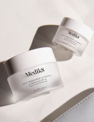 Medik8 skincare jars on a marble surface.