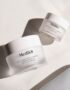 Medik8 skincare jars on a marble surface.