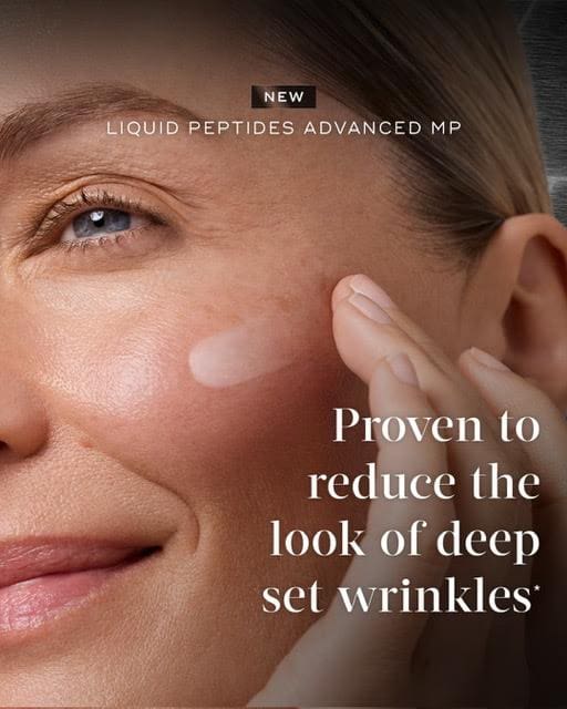 Close-up of a woman applying wrinkle-reducing cream near her eye.