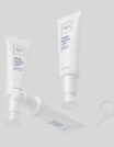 Two white skincare tubes with a clear applicator tip on a light gray background.