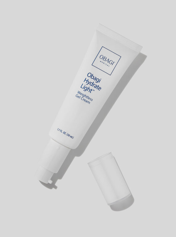 A white tube of skincare product with its cap off on a gray background.
