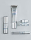 Four sleek silver skincare products on a white background.