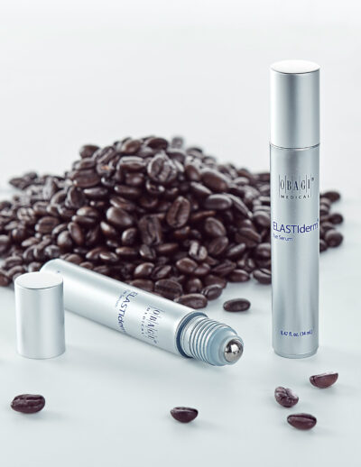 Two sleek silver spray bottles with coffee beans scattered around them.