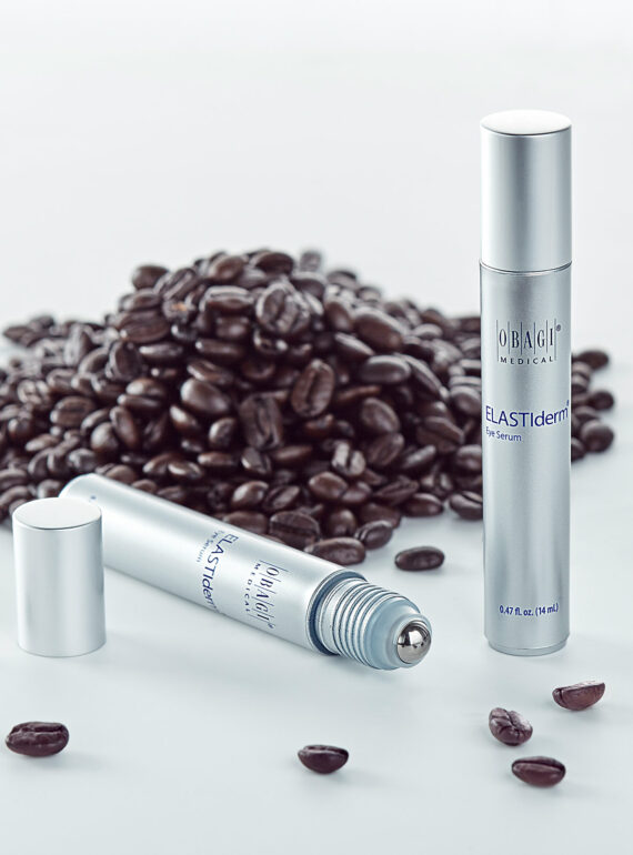 Two sleek silver spray bottles with coffee beans scattered around them.