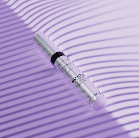 A syringe on a purple striped surface.