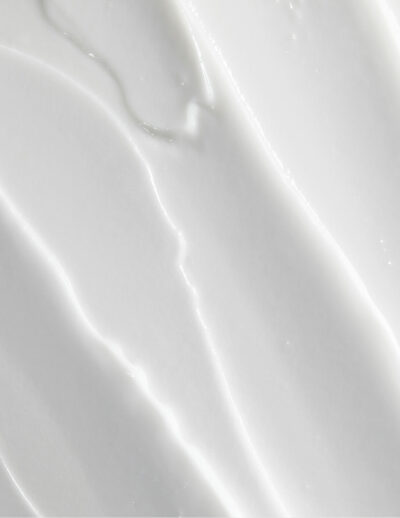 Close-up of smooth white cream texture with subtle swirls and peaks.