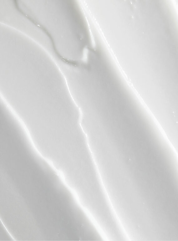 Close-up of smooth white cream texture with subtle swirls and peaks.