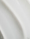 Close-up of smooth white ceramic surface with curved ridges.