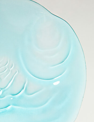 Close-up of a light blue ceramic plate with embossed swirls.