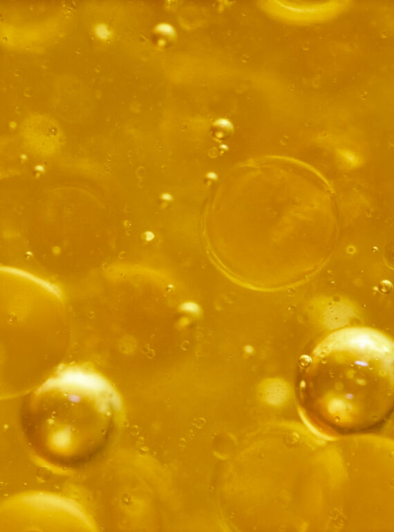 Close-up of golden liquid with bubbles inside.