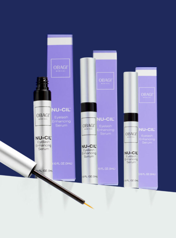 A set of purple and white cosmetic products with a dropper bottle.