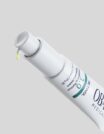 A white tube of OBAGI skincare product with a drop of cream.
